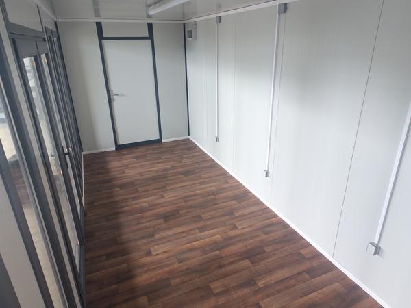 Fertiger Innenraum eines ausgebauten Moduls mit Holzboden vor der Übergabe