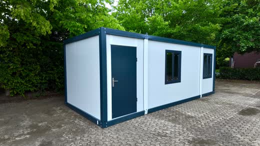 Bürocontainer aus weißen Sandwichpaneelen mit anthrazitfarbenem Rahmen auf einem gepflasterten Hof